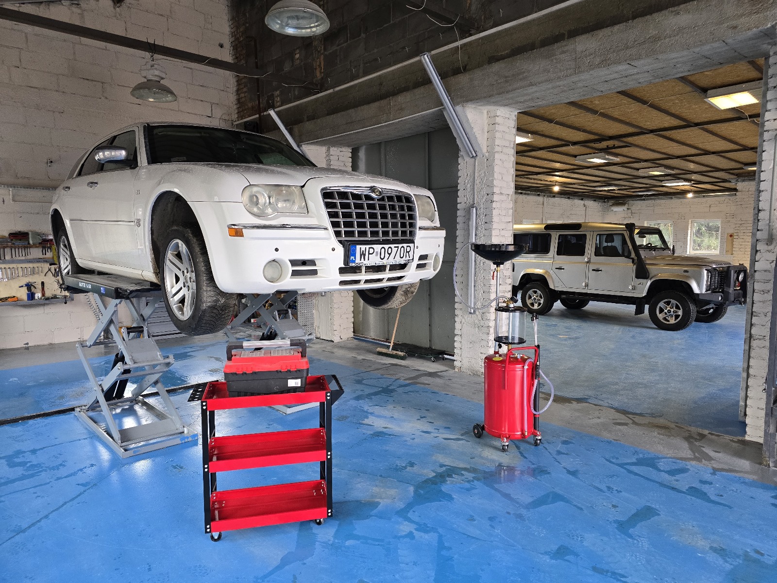Samochód na podnośniku i nowoczesne wyposażenie warsztatu