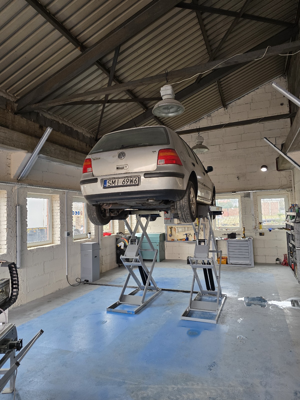 Auto na podnośniku wewnątrz warsztatu